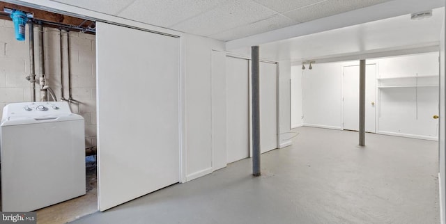 basement featuring a paneled ceiling and washer / clothes dryer