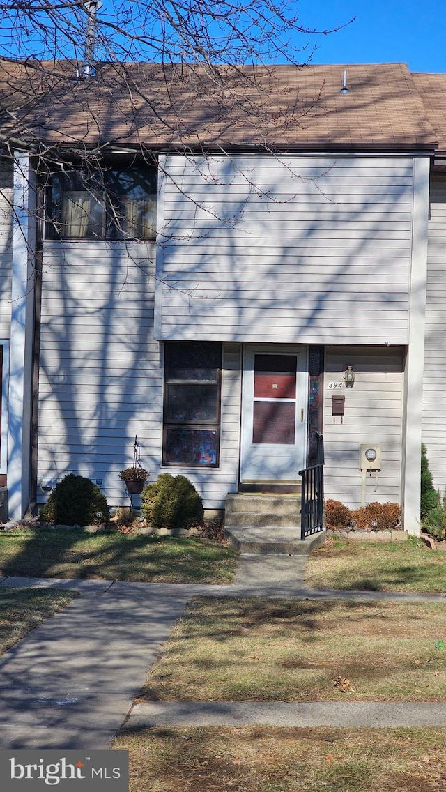 view of exterior entry featuring a lawn