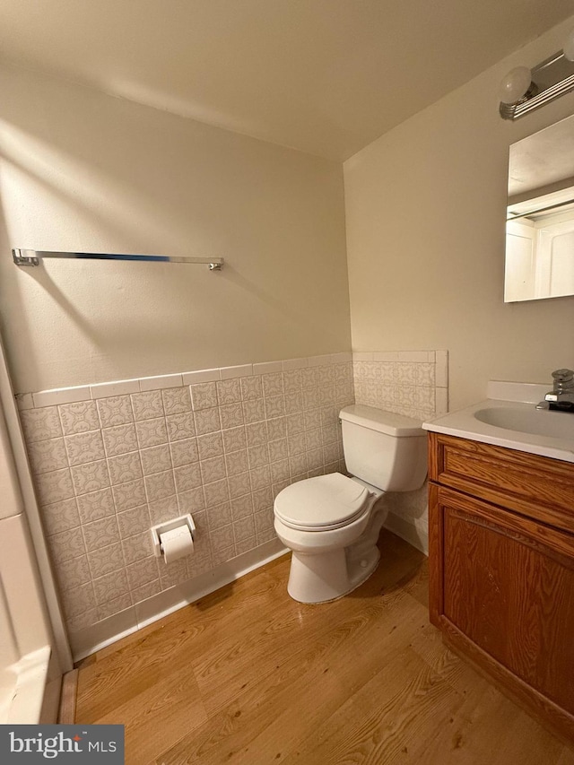 bathroom featuring hardwood / wood-style floors, vanity, toilet, and tile walls