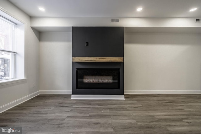 unfurnished living room with dark hardwood / wood-style floors and a fireplace