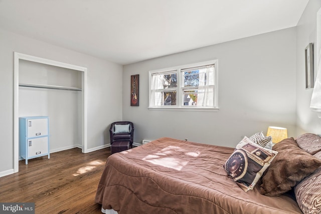 bedroom with dark wood-type flooring and a closet