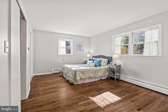 bedroom with a closet, dark wood-type flooring, multiple windows, and a baseboard radiator