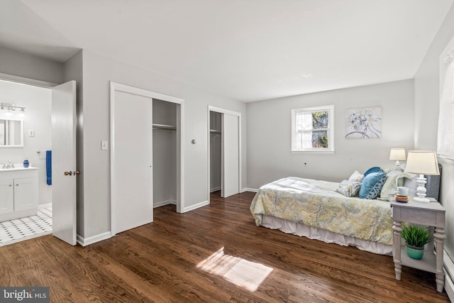 bedroom with ensuite bath, sink, and dark wood-type flooring