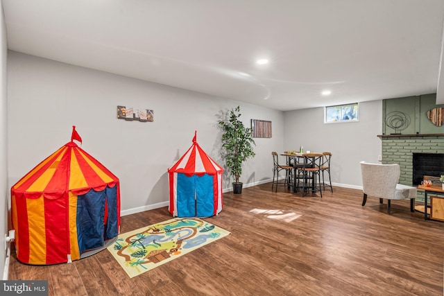 game room with a fireplace and hardwood / wood-style flooring