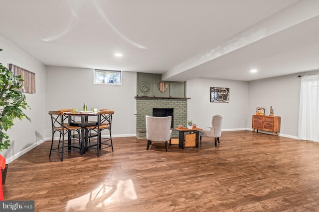 living area with a fireplace and dark wood-type flooring