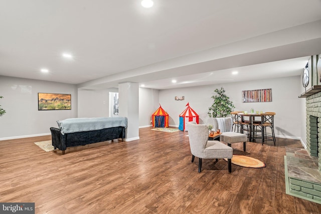 bedroom with hardwood / wood-style flooring and a brick fireplace