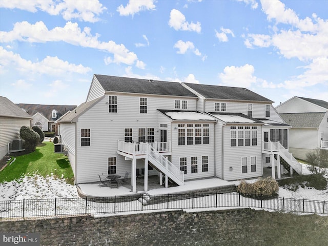 back of house with a wooden deck, a patio, cooling unit, and a fire pit