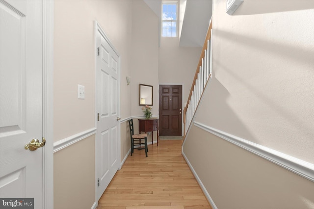 hallway featuring a high ceiling and light wood-type flooring