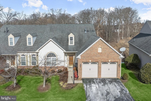 cape cod house featuring a garage and a front lawn