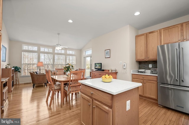 kitchen with tasteful backsplash, a center island, high end refrigerator, and light hardwood / wood-style floors