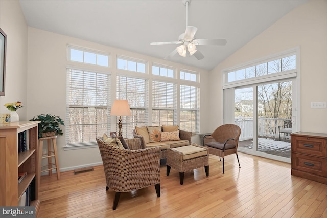 living area featuring ceiling fan, a healthy amount of sunlight, high vaulted ceiling, and light wood-type flooring