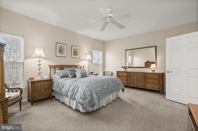 carpeted bedroom with multiple windows and ceiling fan