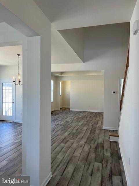 interior space with wood finished floors, an inviting chandelier, baseboards, and plenty of natural light