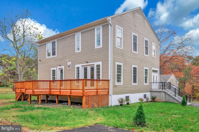 rear view of house featuring a yard and a deck