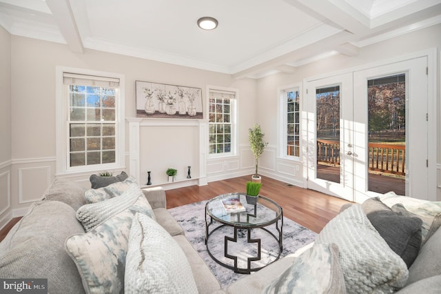 living room with hardwood / wood-style flooring, beam ceiling, and crown molding