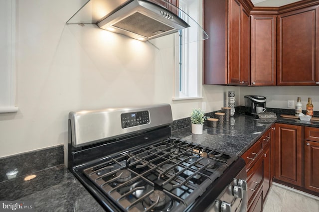 kitchen featuring custom exhaust hood, dark stone counters, and stainless steel gas range