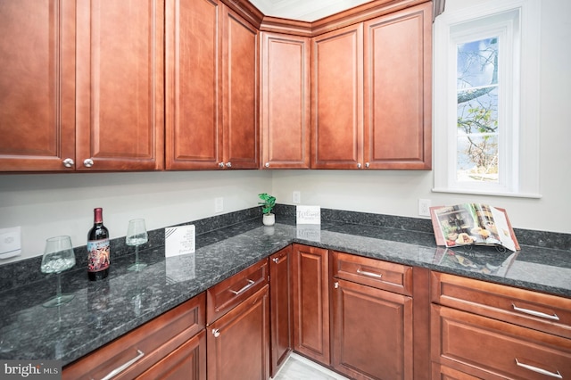 kitchen with dark stone countertops and crown molding