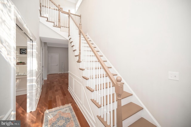 stairs with a high ceiling and hardwood / wood-style flooring