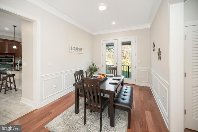 dining area with french doors, hardwood / wood-style flooring, and ornamental molding