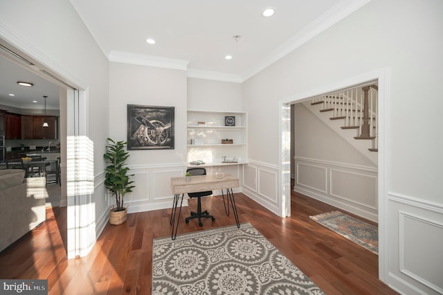 office space featuring built in shelves, dark hardwood / wood-style flooring, and crown molding