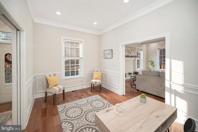 sitting room featuring wood-type flooring and ornamental molding