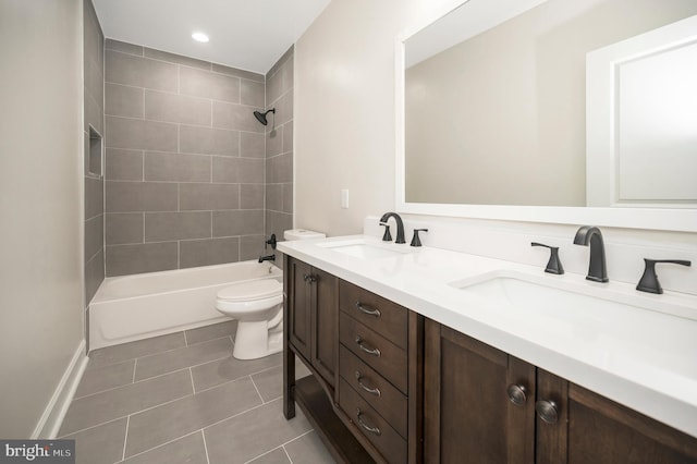 full bathroom featuring tile patterned floors, vanity, tiled shower / bath combo, and toilet