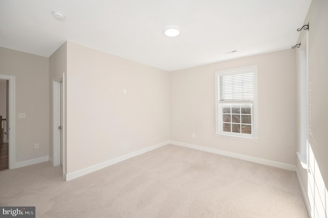 unfurnished room featuring light carpet