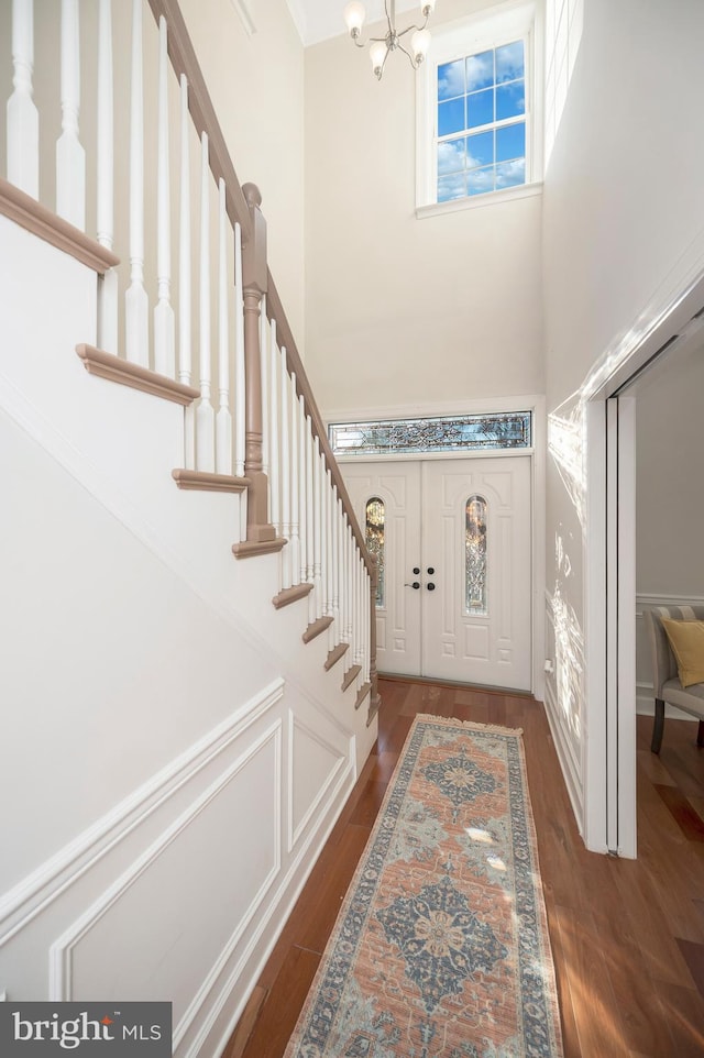 entrance foyer featuring dark hardwood / wood-style floors, a high ceiling, and an inviting chandelier