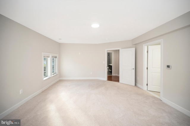 unfurnished room featuring light carpet