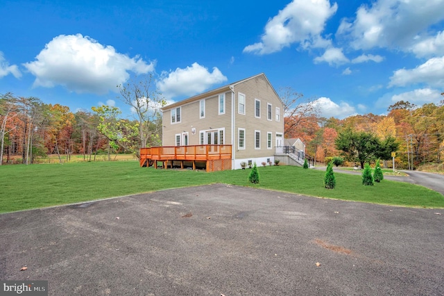 exterior space with a front lawn and a wooden deck