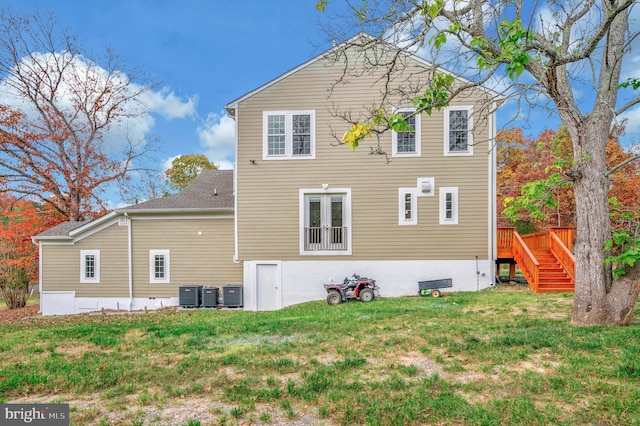 rear view of house featuring a yard and central AC unit