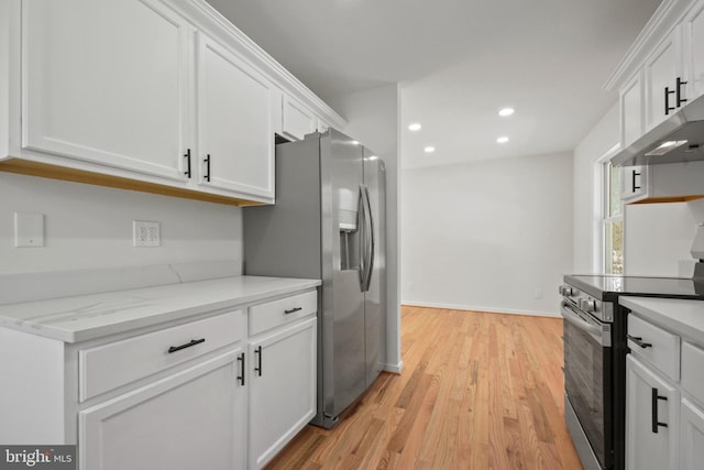 kitchen with light stone countertops, appliances with stainless steel finishes, light hardwood / wood-style flooring, and white cabinetry