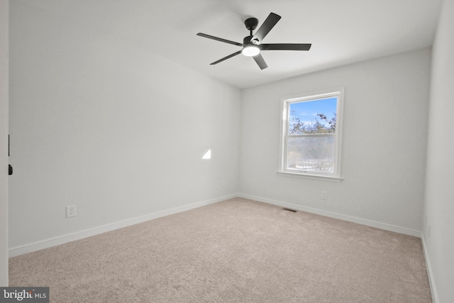 spare room with ceiling fan and light colored carpet