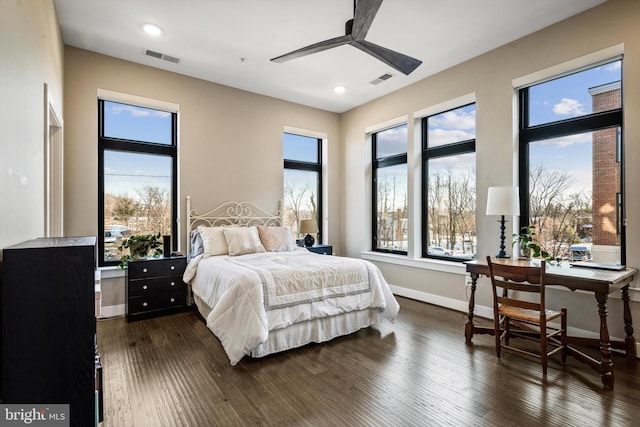 bedroom with ceiling fan, dark hardwood / wood-style flooring, and multiple windows