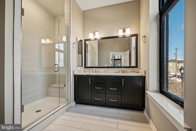 bathroom featuring a shower with door and vanity