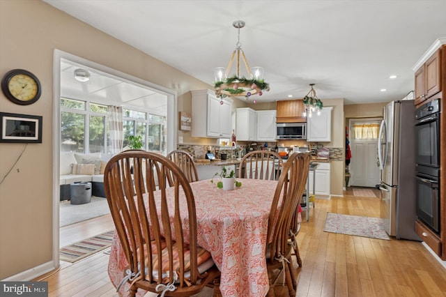 dining room featuring light wood-type flooring, baseboards, and recessed lighting