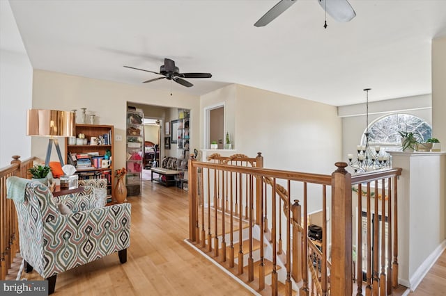 interior space with an inviting chandelier, wood finished floors, and an upstairs landing