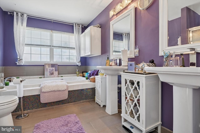 bathroom with toilet and a garden tub