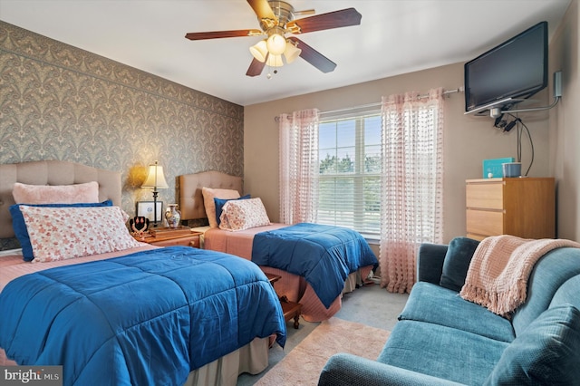 carpeted bedroom featuring wallpapered walls and a ceiling fan