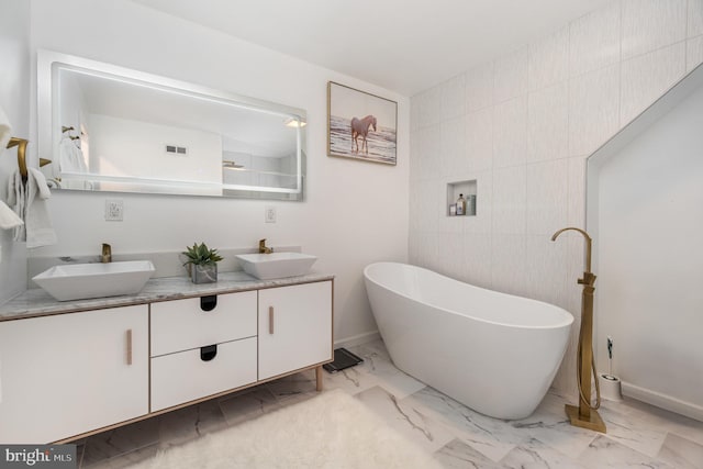 bathroom featuring vanity, a bathtub, and tile walls