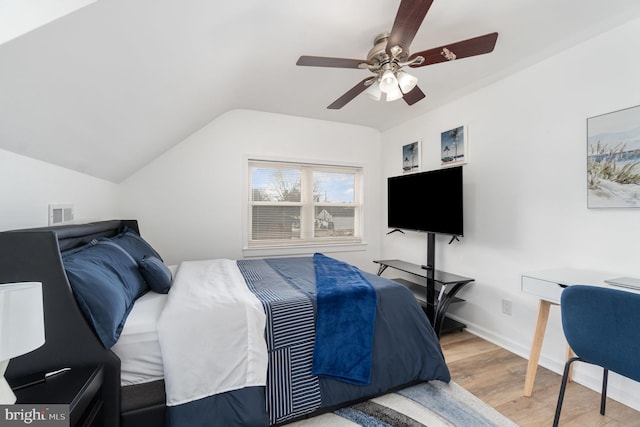 bedroom with ceiling fan, vaulted ceiling, and light wood-type flooring