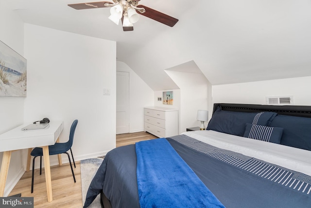 bedroom with light wood-type flooring, vaulted ceiling, and ceiling fan