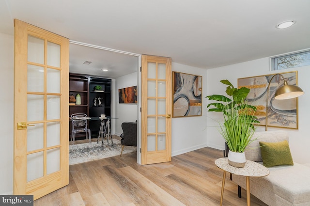 sitting room featuring wood-type flooring and french doors