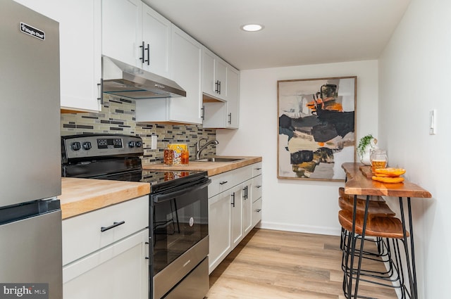 kitchen featuring white cabinetry, stainless steel appliances, sink, light wood-type flooring, and butcher block countertops