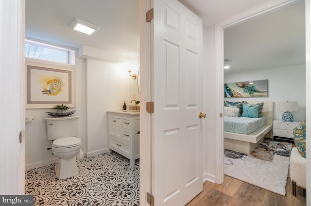 bathroom featuring wood-type flooring, toilet, and vanity