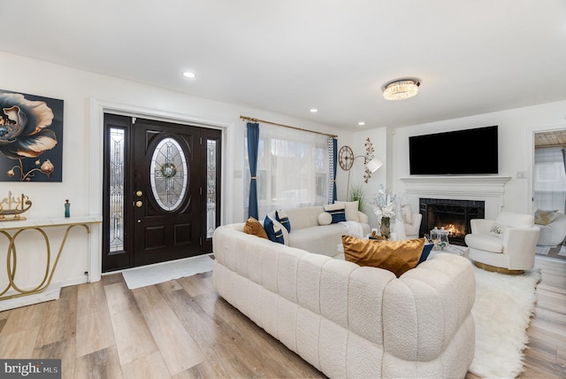 living room with light wood-type flooring and a tile fireplace