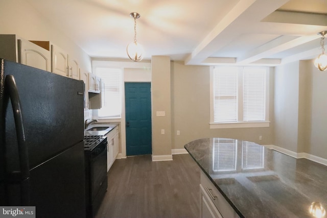 kitchen featuring dark wood-type flooring, sink, decorative light fixtures, black refrigerator, and stove