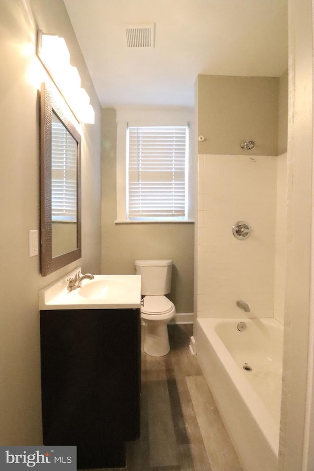 full bathroom featuring vanity, wood-type flooring,  shower combination, and toilet