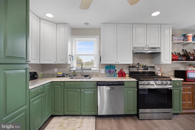 kitchen with stainless steel appliances, white cabinets, sink, and light hardwood / wood-style floors