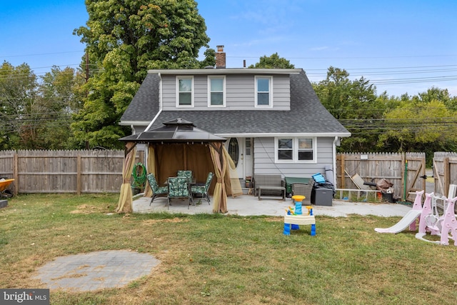 back of property featuring a lawn, a patio area, and a gazebo